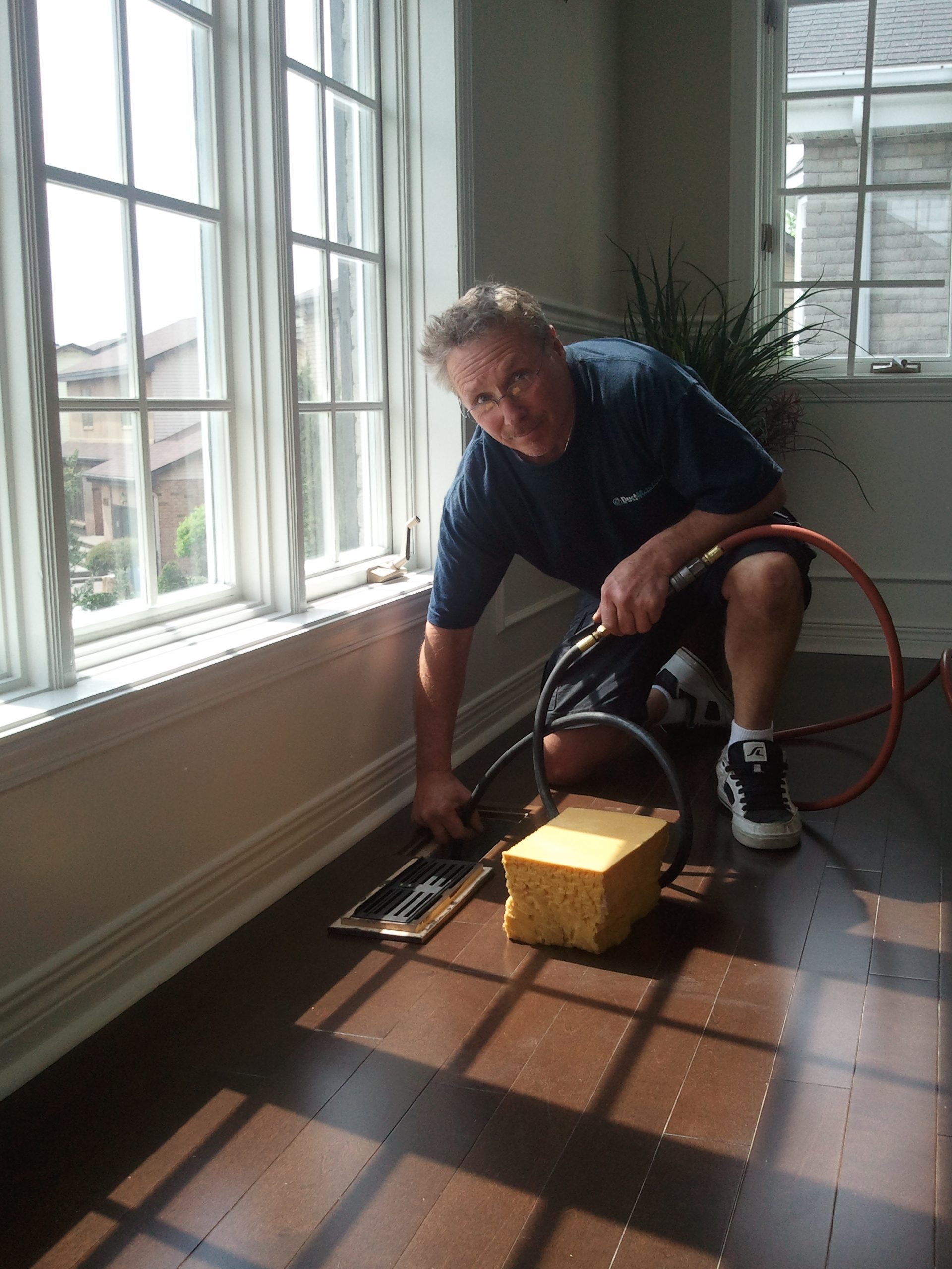 Art cleaning a floor vent in a Montreal home